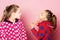 Kids pose on pink background. Girls in polka dotted pajamas