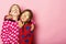 Kids pose on pink background sending kisses, copy space