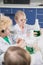 Kids in protective glasses and lab coats making experiment