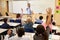 Kids raising hands to answer in an elementary school class