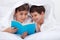 Kids reading under the blanket