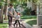 Kids ride bicycle push by his father