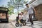 Kids ride bicycle push by his father