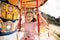 Kids riding on colorful amusement carousel