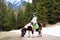 Kids riding pony. Child on horse in Alps mountains