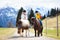 Kids riding pony. Child on horse in Alps mountains