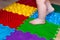 Kids Rubber play floor. Orthopedic massage mat, baby foot on massaging puzzle rug. Barefoot boy walking