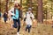 Kids run ahead of family hiking in forest, California, USA