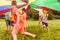 Kids running in circle under colorful parachute