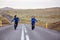 Kids running on an empty road in beautiful nature in Snaefellsjokull National Park in Iceland, autumntime