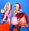 Kids in Santa Claus hats open gift boxes and packages