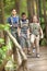 Kids scouts traveler with backpack hiking bridge in forest