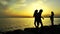 Kids Silhouette throwing Stones to Sea