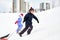 Kids with sleds climbing snow hill in winter