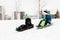 Kids sliding on sleds down snow hill in winter