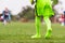 Kids soccer football - little goalkeeper in green goalkeeper jersey at soccer field