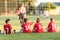 Kids soccer players sitting behind goal watching football match