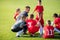 Kids soccer waiting in out with coach