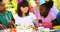 Kids standing near table laid with food and celebrating a birthday