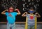 Kids in superhero costume flexing their arms against blackboard in background