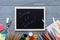 Kids supplies on on grey wooden desk, back to school background written on chalkboard for modern primary education, new year start