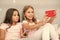 Kids taking selfie in bedroom. Pajamas party concept. Girlish leisure happy childhood. Girls long hair with smartphones