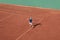 Kids tennis sport concept. Child tennis player serve ball on red clay court. High view from above, background Copy space