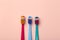 Kids toothbrushes of different colors on a pink background. Teeth and oral hygiene for children