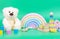Kids toys collection. Teddy bear, wooden rainbow and baby educational toys on light green background