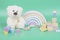 Kids toys collection. Teddy bear, wooden rainbow and baby educational toys on light green background