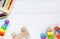 Kids toys: pyramid, wooden blocks, xylophone, train on white wooden background. Top view. Flat lay.