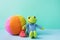 Kids Toys Small Plush Frog Holding Red Heart Multicolored Textile Soft Ball on Blue Green Background. Banner Placeholder Charity