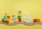 Kids toys on toy wooden railway on yellow background