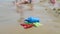 Kids toys on tropical sand beach, family vacation. Plastic shovel toy for kid play on the sea side. Concept of beach