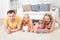 Kids using tablets lying on carpet