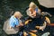 Kids walk by stepping stones, feeding koi fishes in pond