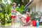 Kids wash dog in summer garden. Water hose fun