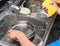 Kids washing dishware in kitchen sink with soapy sponge