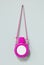 Kids water bottle hanging on cement wall background. Pink child bag or lunch box for take to school. Blank object for your design