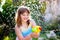 Kids with water gun toy in garden. Outdoor fun