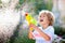 Kids with water gun toy in garden. Outdoor fun