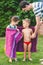 Kids wipes with towel after swimming in home inflatable pool. Brother and sister giggling wrapped in beach towels in the courtyard