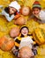 Kids among yellow leaves and orange pumpkings