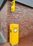 Kiel, Germany - 07. July 2022. A yellow german postbox at a red brick wall with a german post sign above it