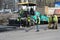 KIEV, UKRAINE - APRIL 6, 2017: Workers operating asphalt paver machine and heavy machinery during road repairs