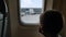 KIEV, UKRAINE-JULY 20, 2021: travel during pandemic, child passenger in a mask looks out the plane window while driving