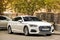 Kiev, Ukraine - May 3, 2019: White Audi A5 parked in the city center against a tree