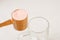 Kiev, Ukraine - May 31, 2020: A full measuring cup of pink protein powder from optimum nutrition with strawberry flavor