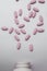 KIEV, UKRAINE - OCTOBER 14, 2020: Large pink oval tablets. Pills on a gray background spill