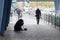 Kiev, Ukraine - October 24, 2018: Beggarly old woman sits on the sidewalk surrounded